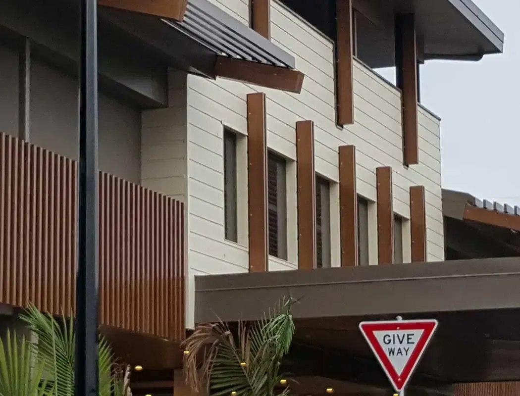 Modern building with light-colored facade, wooden accents, and a 