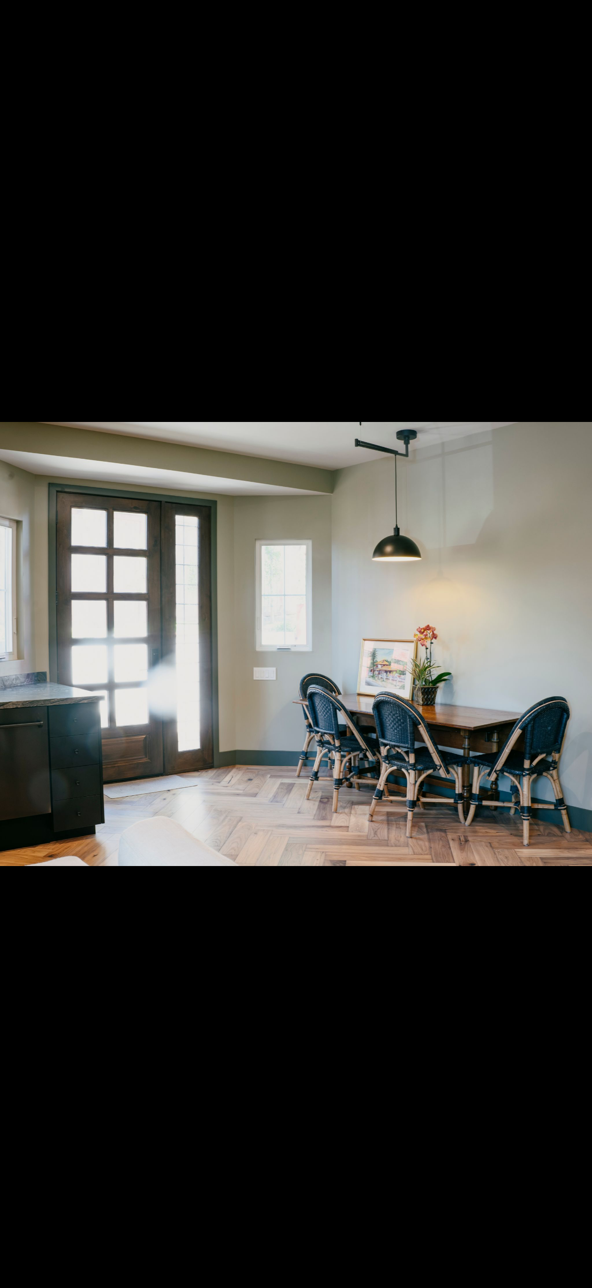 Dining room with table, chairs, and large window.