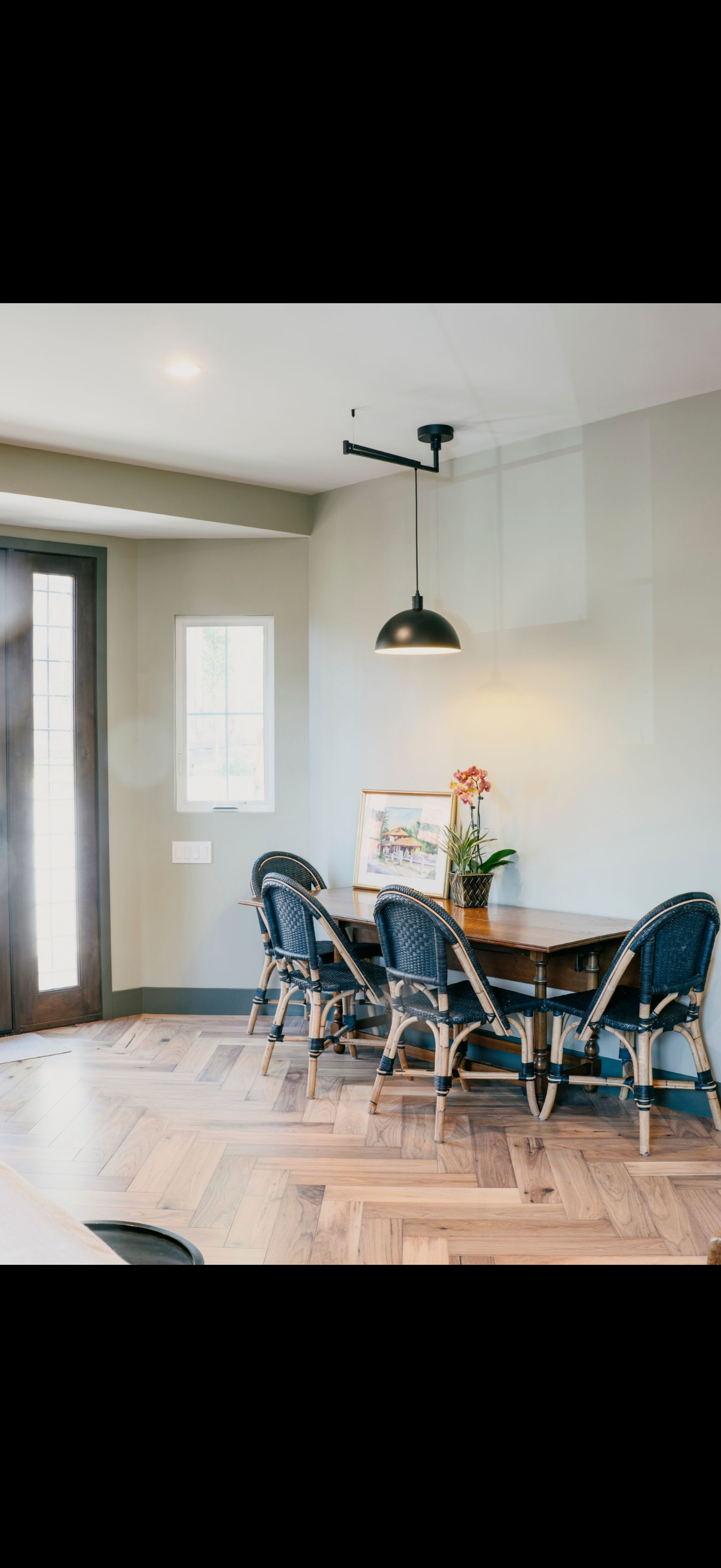 Dining room with a dark table, chairs, and a pendant light.