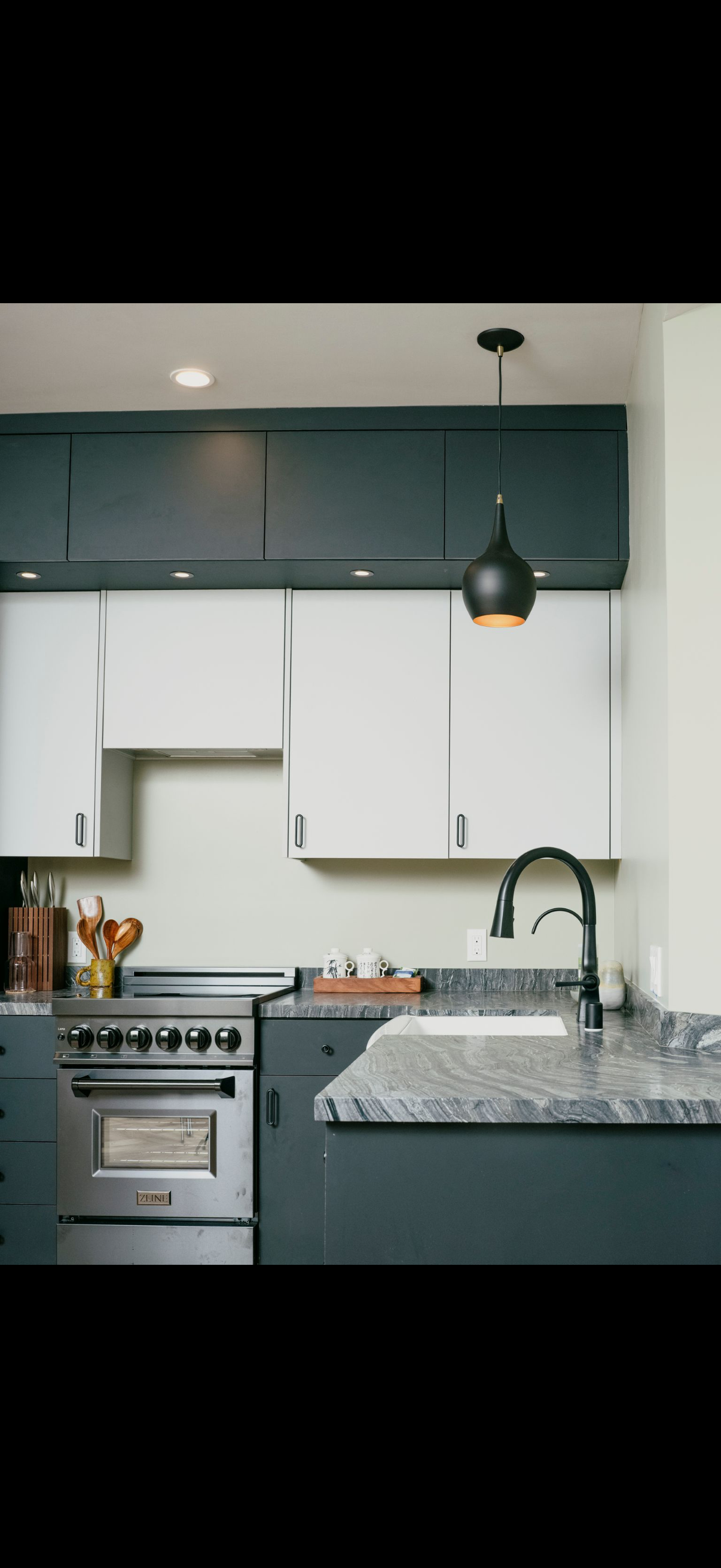 A kitchen with dark cabinets, stainless steel appliances, and a granite countertop.