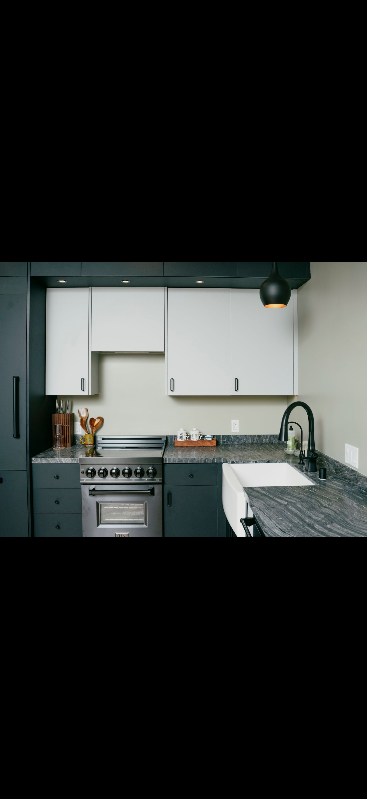 Kitchen with dark cabinets, stainless steel appliances, and black granite countertops.