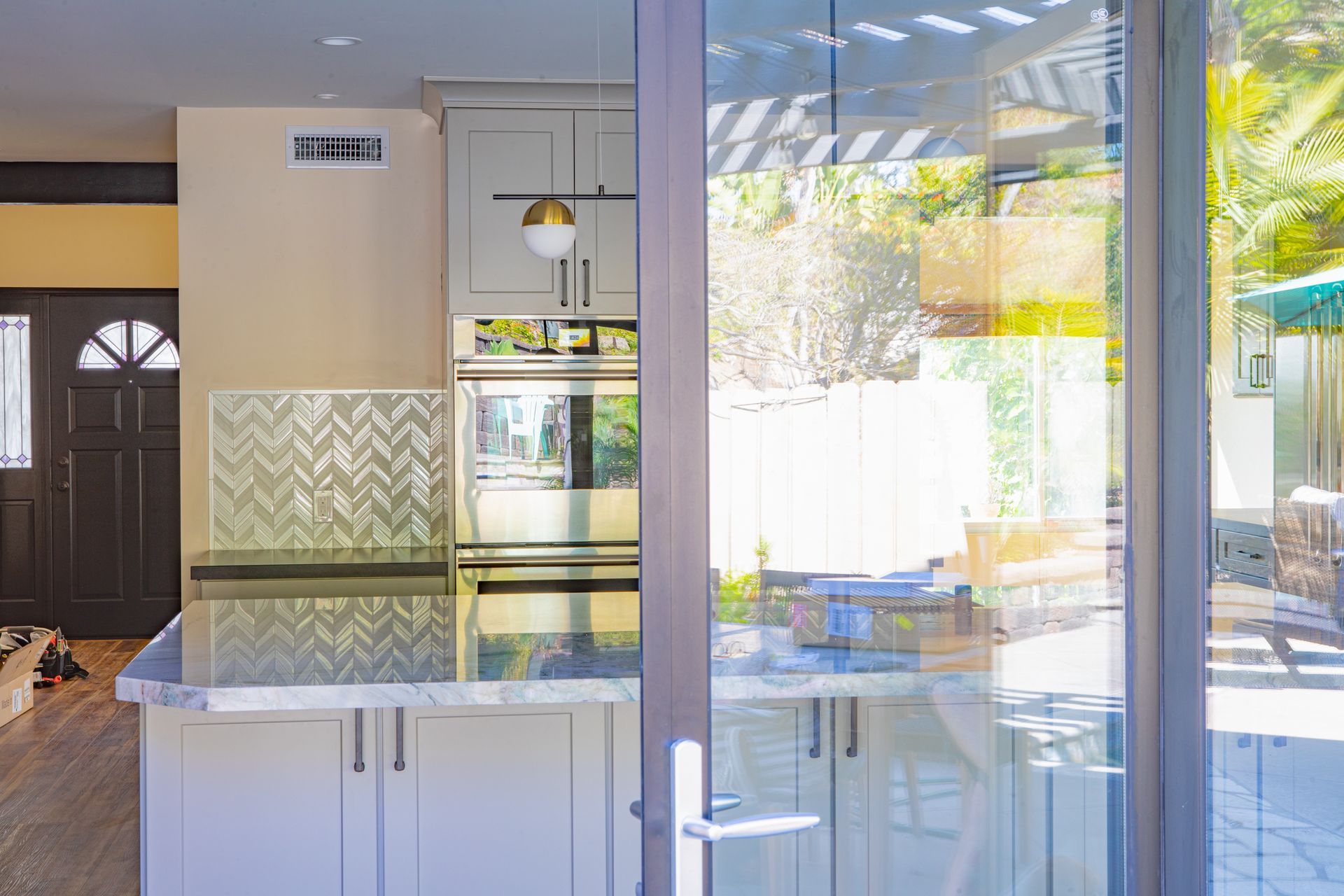 Kitchen with gray cabinets, granite countertop, and glass door to a patio.