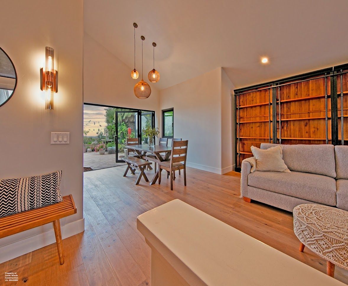 Dining room with table, chairs, and open doors to a garden. Neutral colors with wood accents.