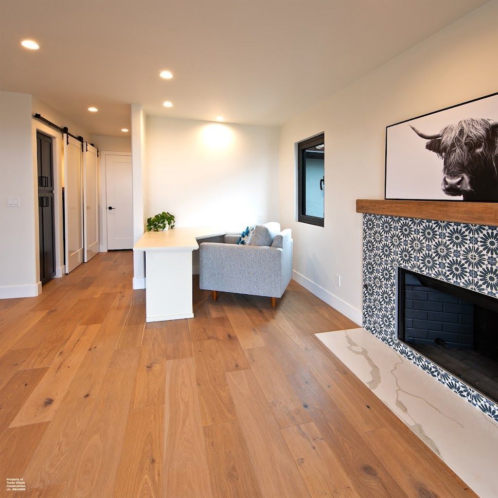 Living room with hardwood floors, a fireplace, a desk, and a light blue couch.