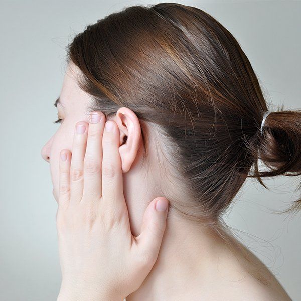 Donna si tocca l'orecchio