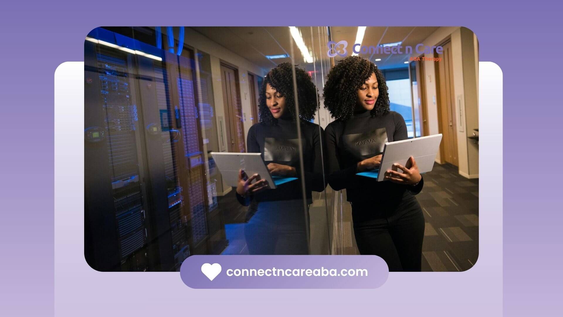 ABA girl standing in a server room holding a laptop & working with a slight smile on North Carolina.