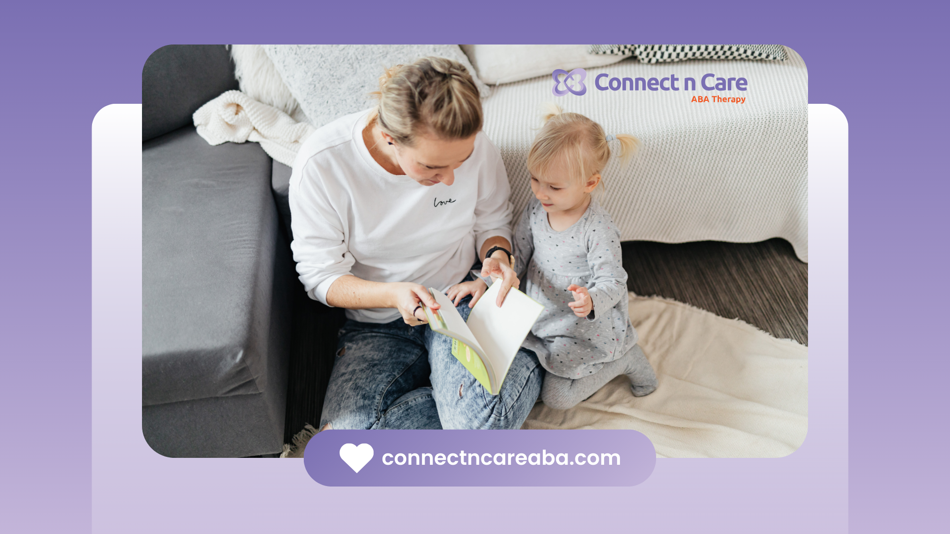 Person reading a book with a baby on a rug.