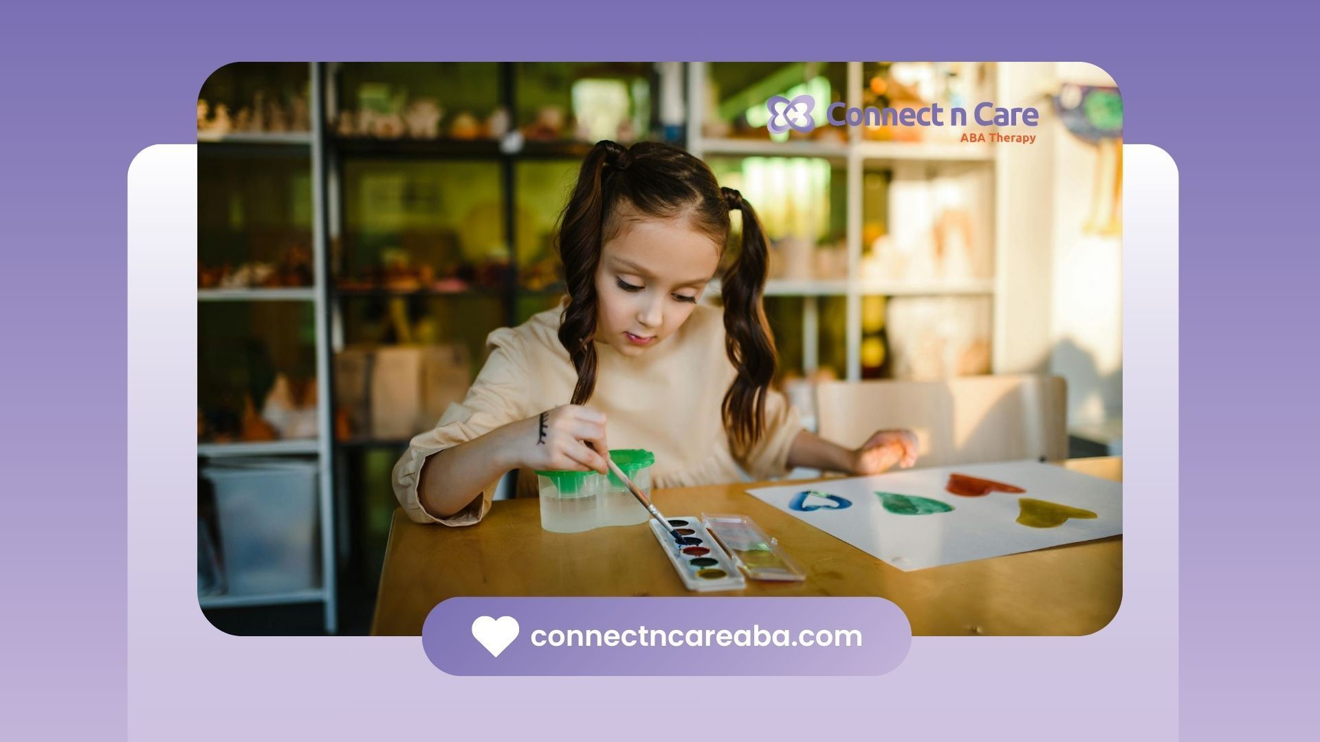 Autistic girl painting colorful shapes on paper with watercolors at a table during ABA therapy in NC