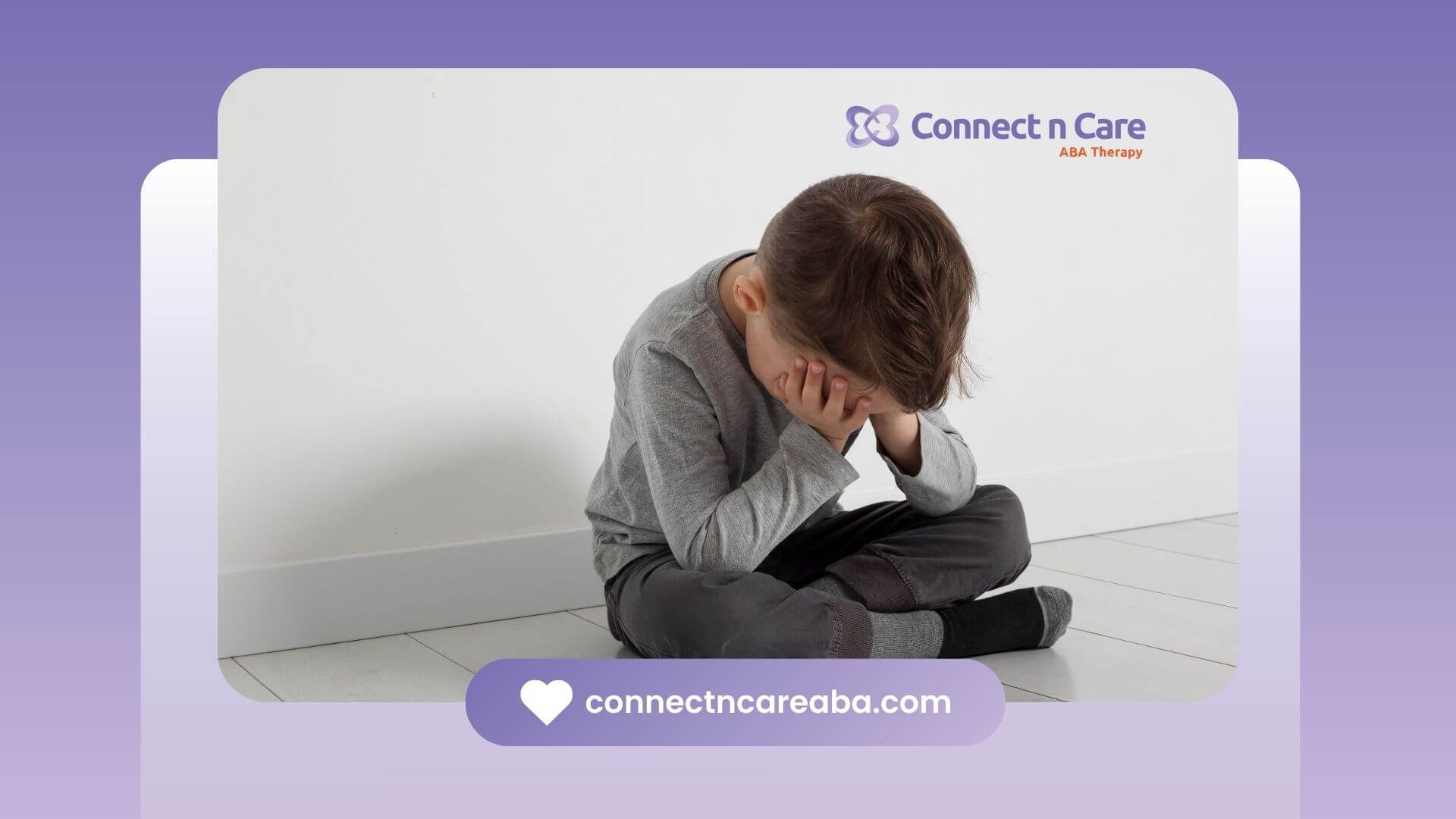 An autistic child sitting on the floor, holding their head in frustration or distress after therapy.