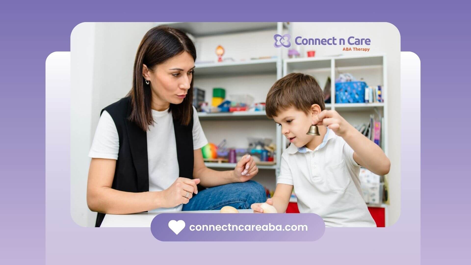 A BCBA is talking to a young boy who is sitting at a table in ABA therapy.