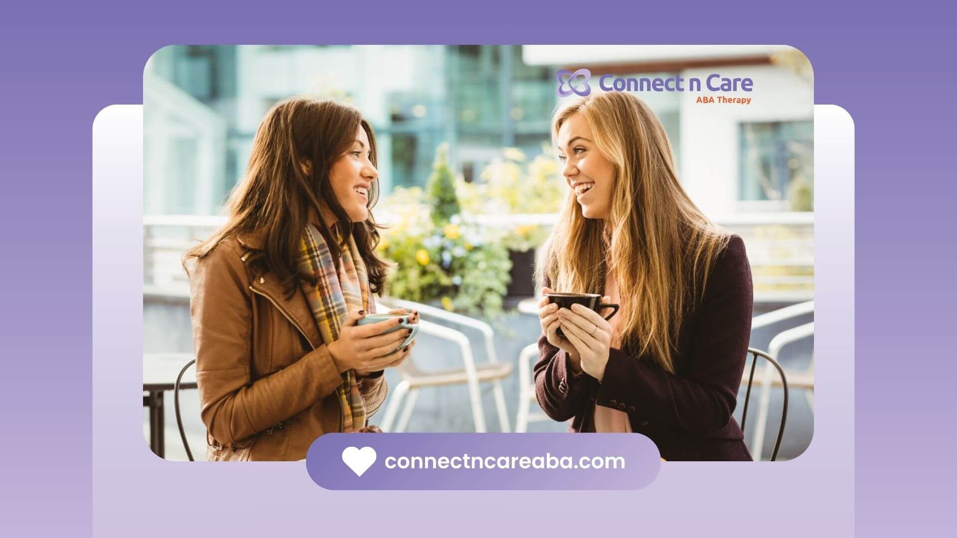 Two women with autism smiling and drinking coffee at a cafe.