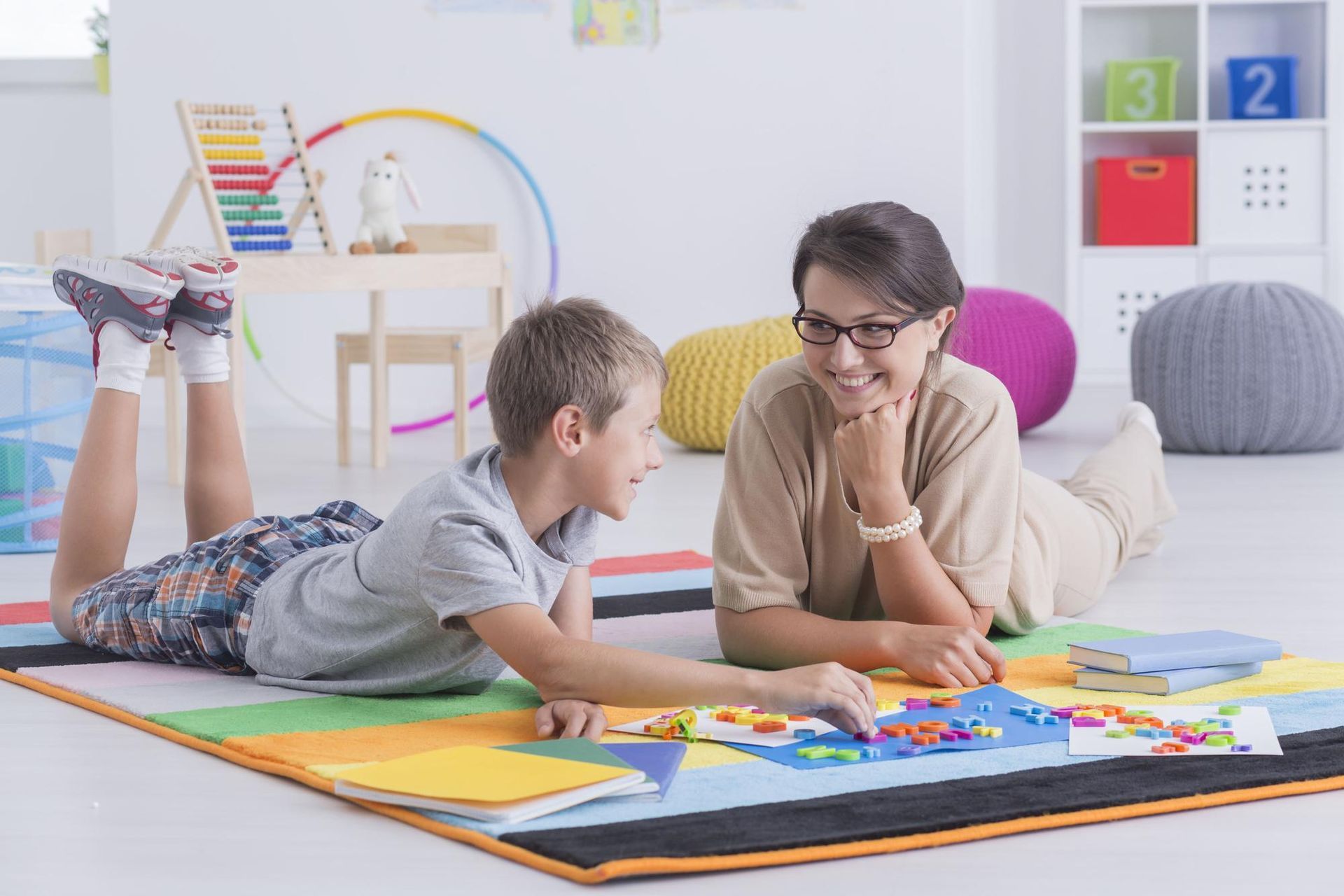 A boy and a girl sitting at a table playing with wooden blocks 