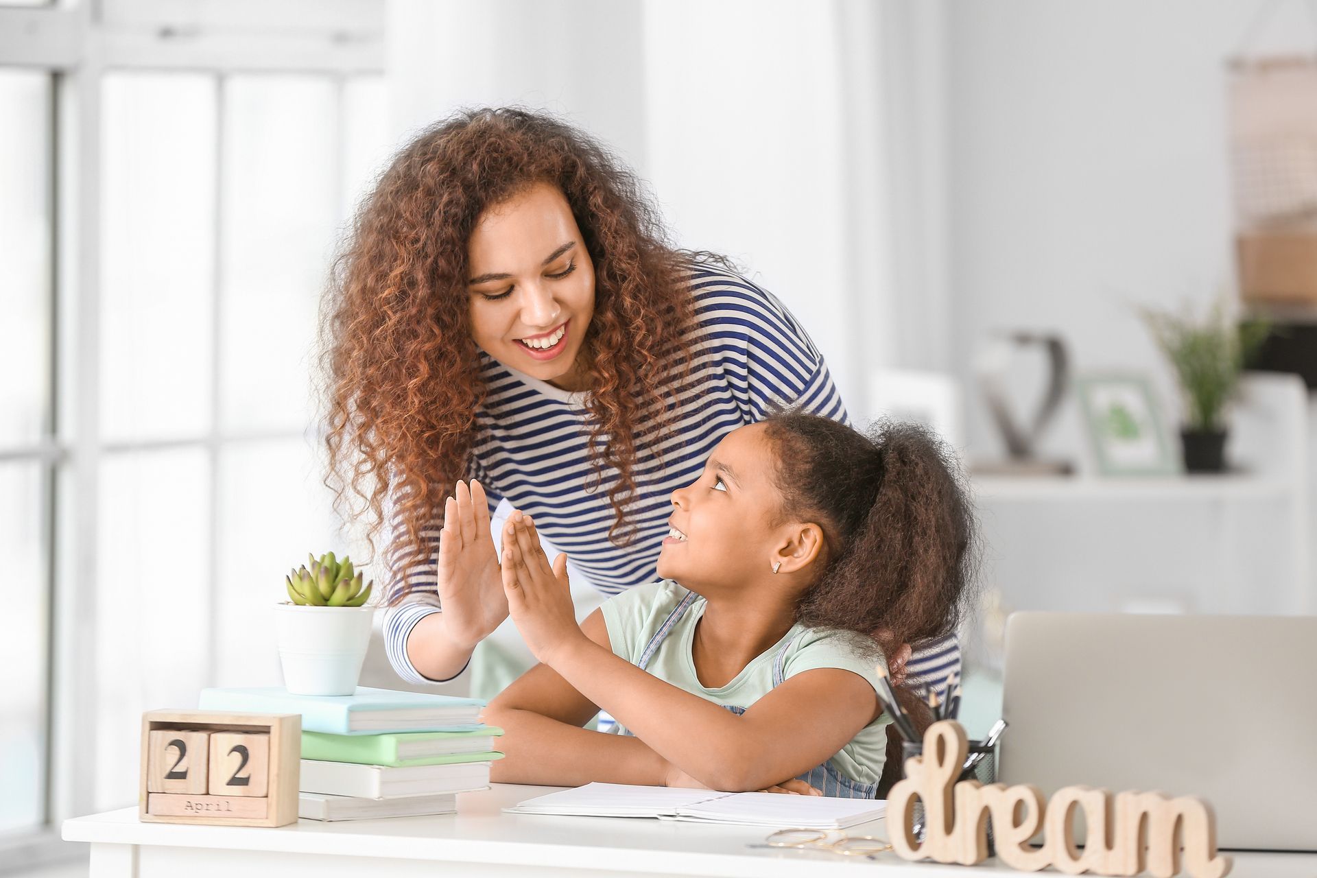 A boy and a girl sitting at a table playing with wooden blocks 