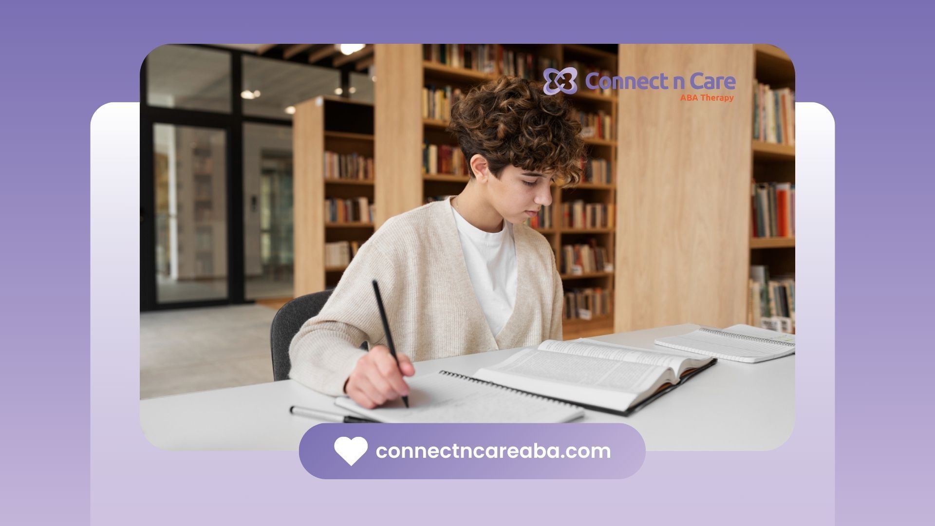 An aspiring RBT with curly hair is sitting at a table in a library.