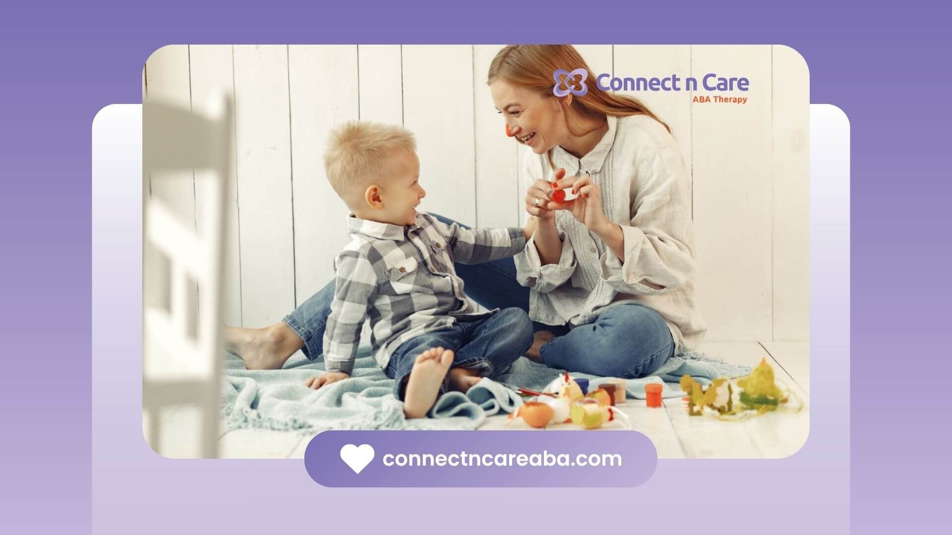 Therapist and child with autism laughing and playing together on a blanket.