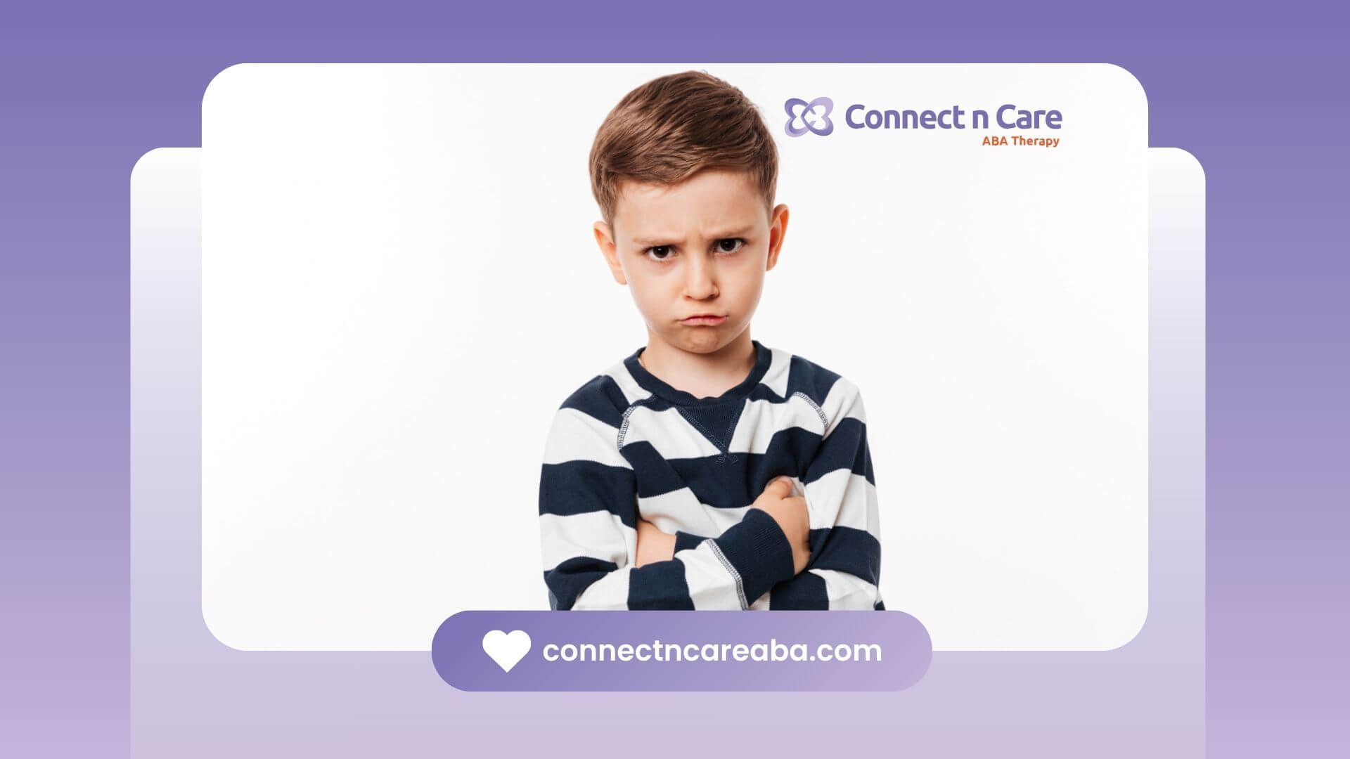 An autistic boy with a frown, crossing his arms and looking upset.