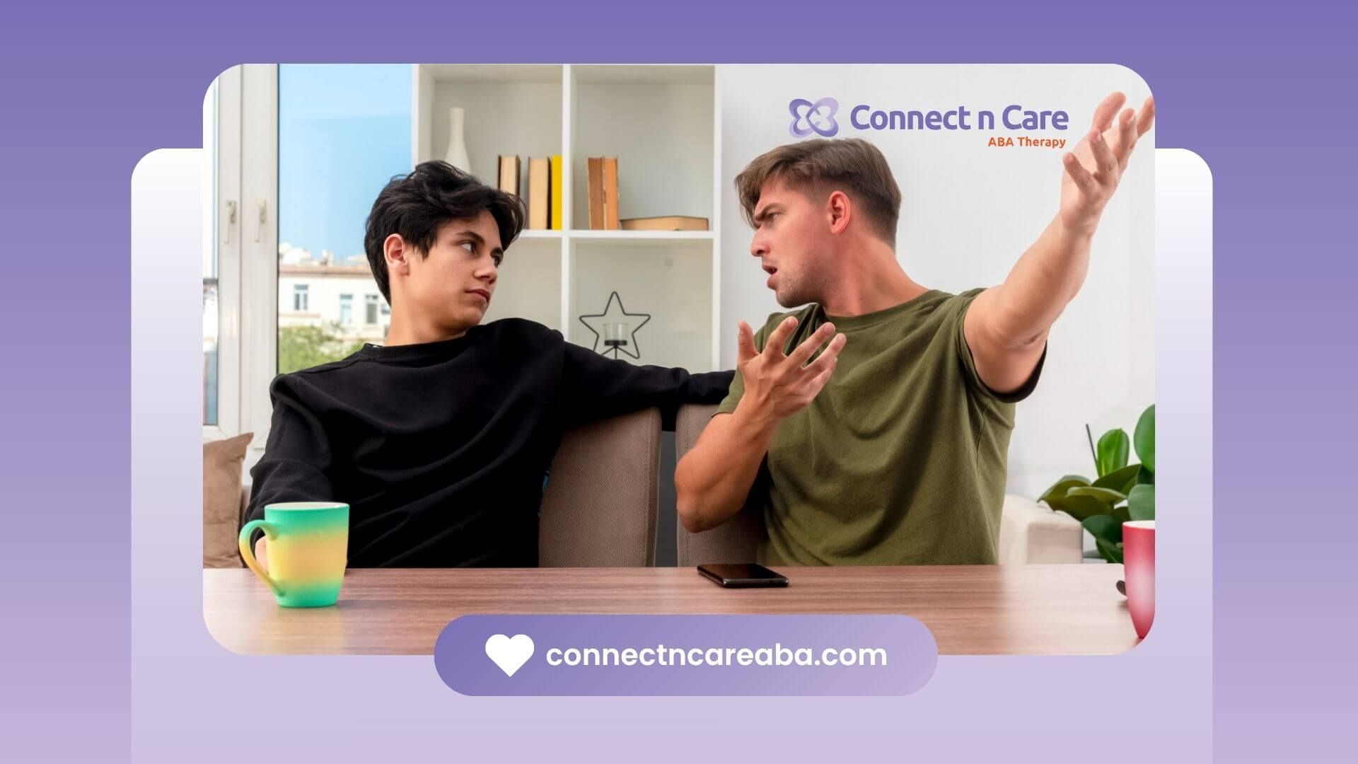Two teens with autism sitting at a table, one speaking intensely to the other.