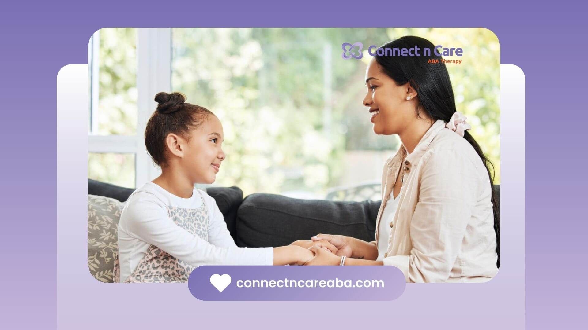 BCBA and child sitting on a sofa, holding hands and talking calmly.