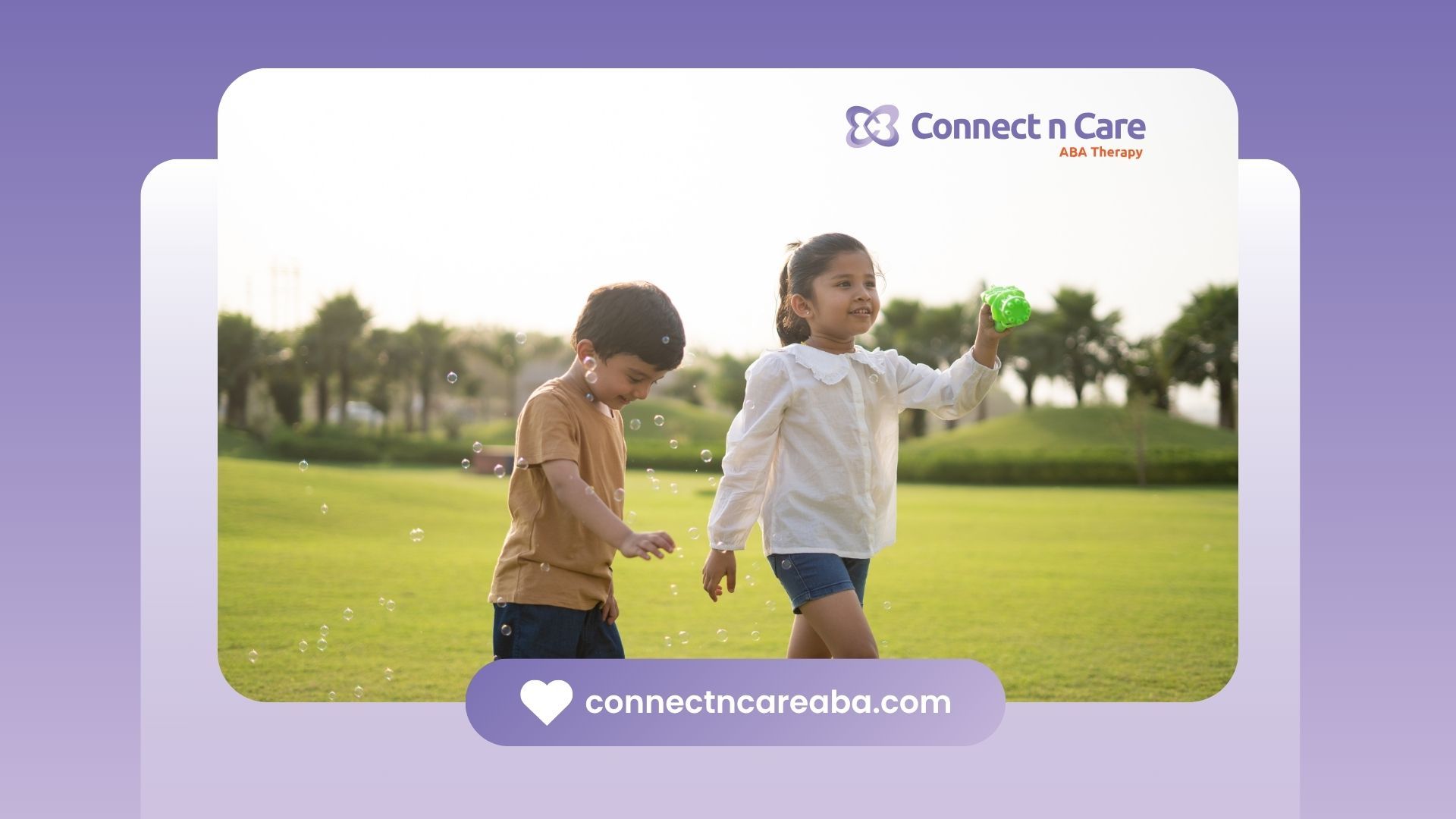 A boy and a girl are playing with bubbles in a park.