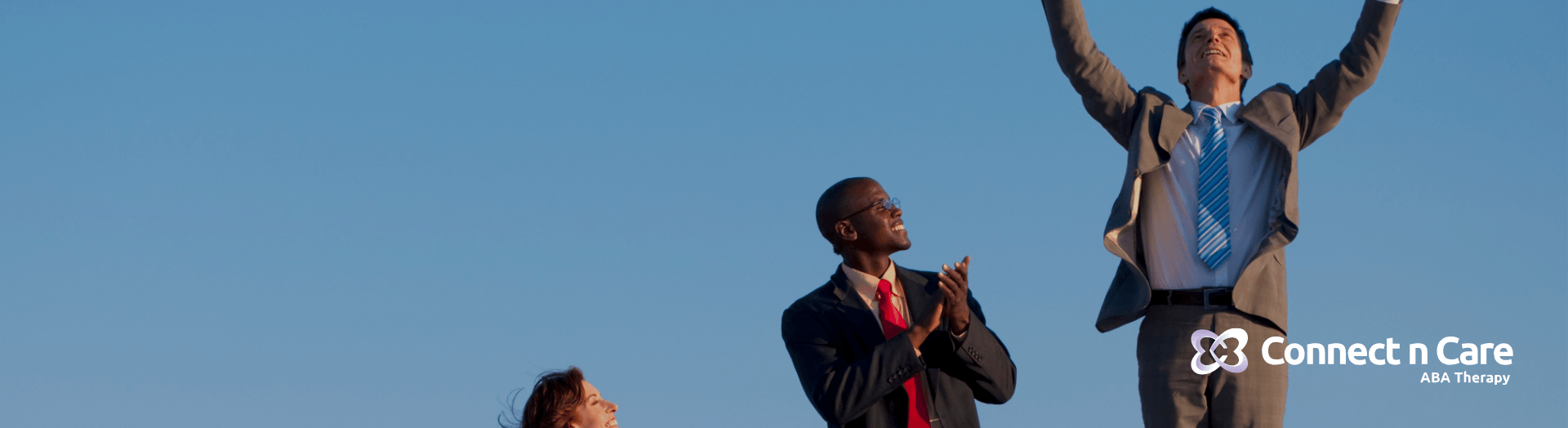 A group of therapists dressed in formal attire, standing on podiums with a man celebrating success