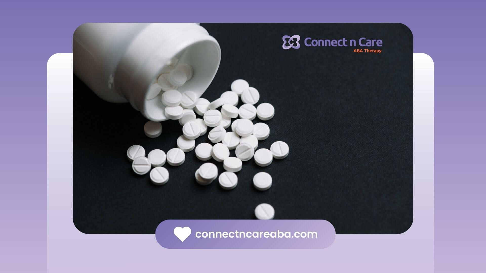 White pills spilling from a bottle onto a dark surface.
