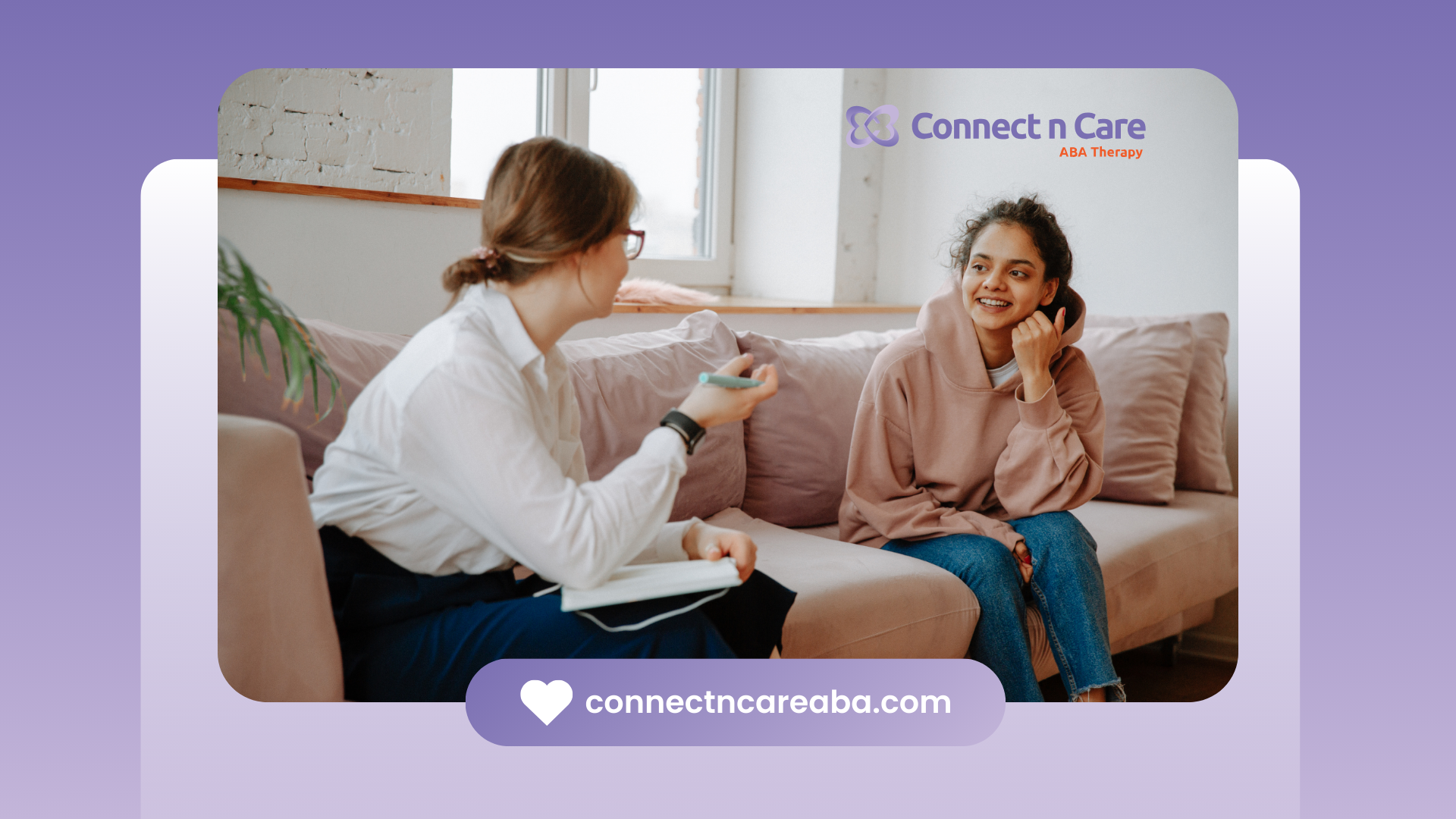 A woman is sitting on a couch talking to another woman.