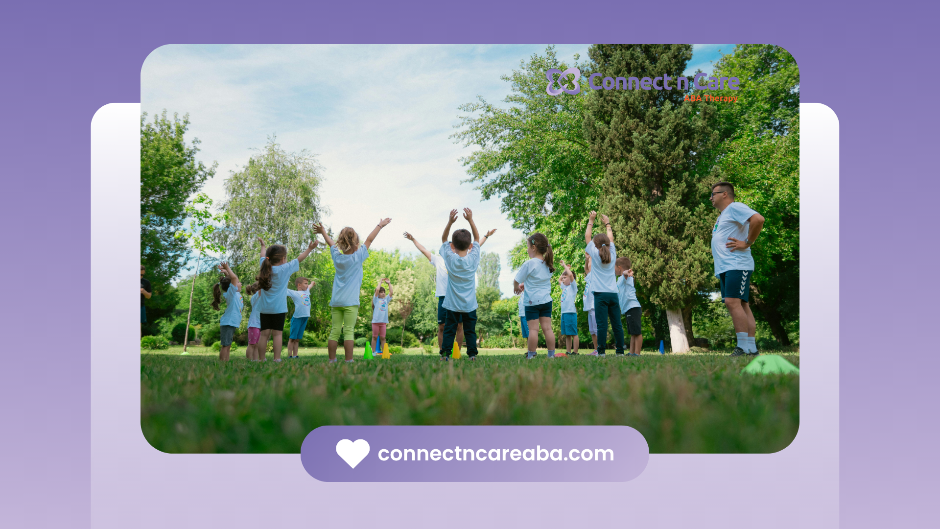 A group of children are standing in a park with their arms in the air.