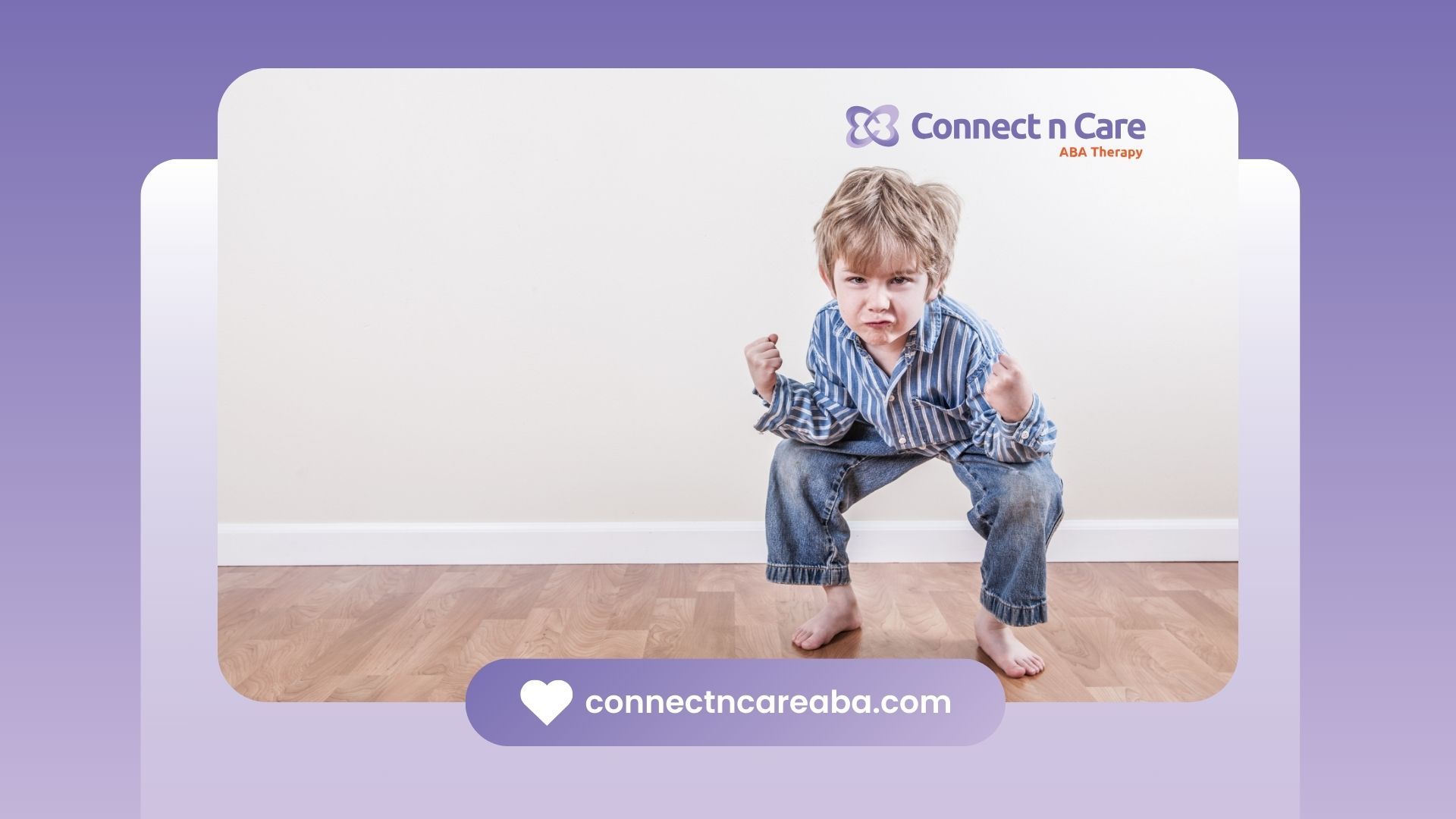 A young boy is squatting on a wooden floor.