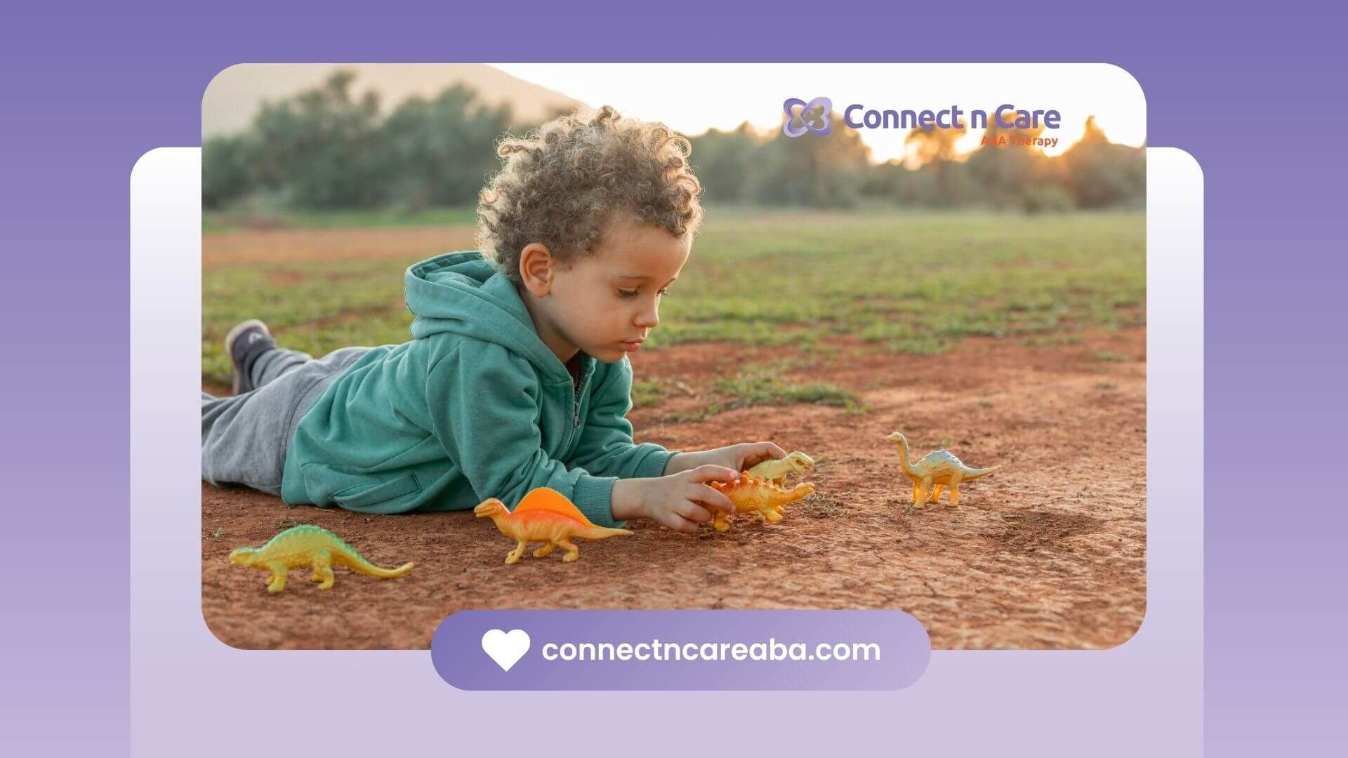 A boy with autism playing with dinosaur toys on the ground outdoors.