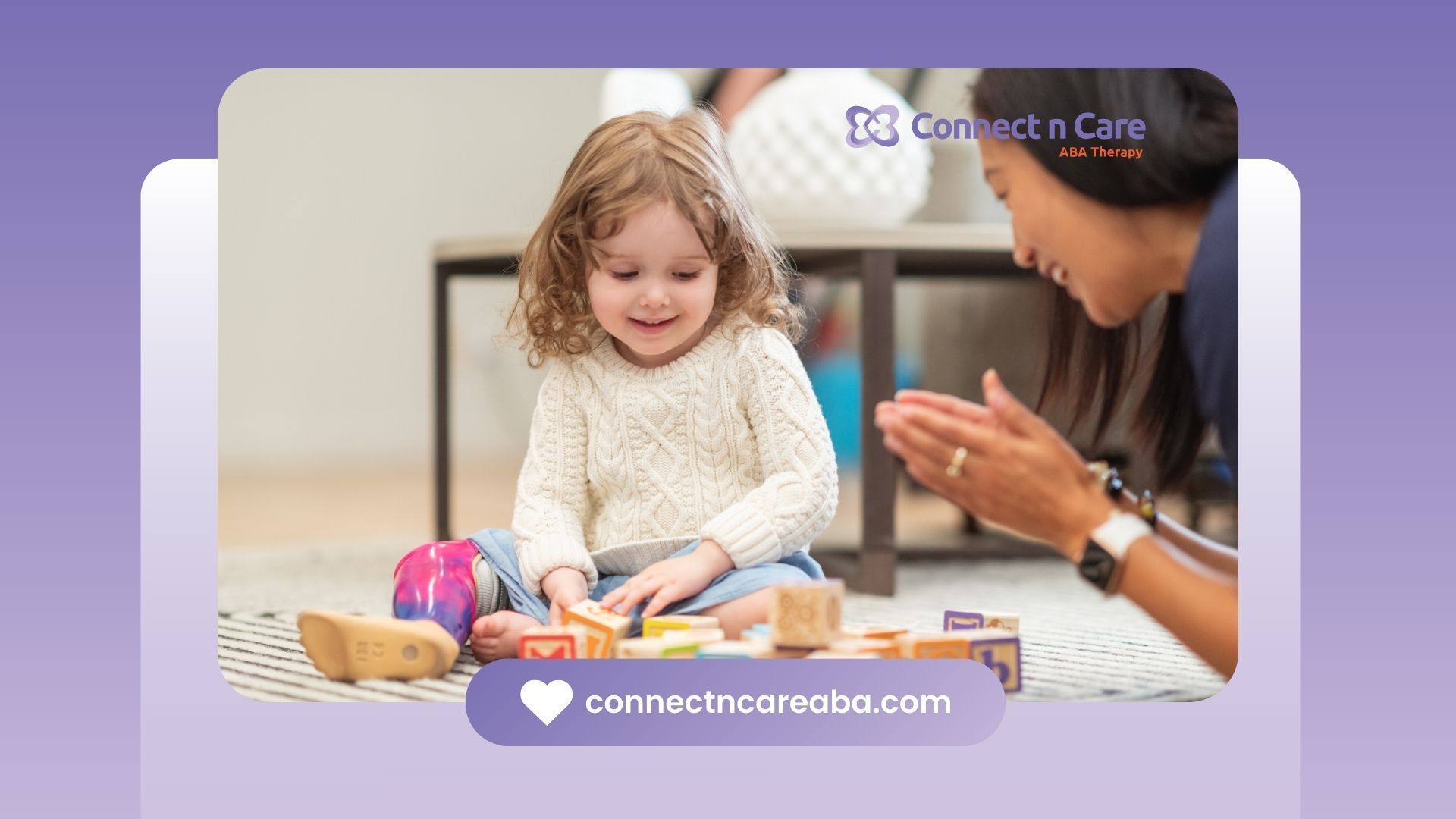 A young girl smiles playing with blocks while an adult woman claps hands.