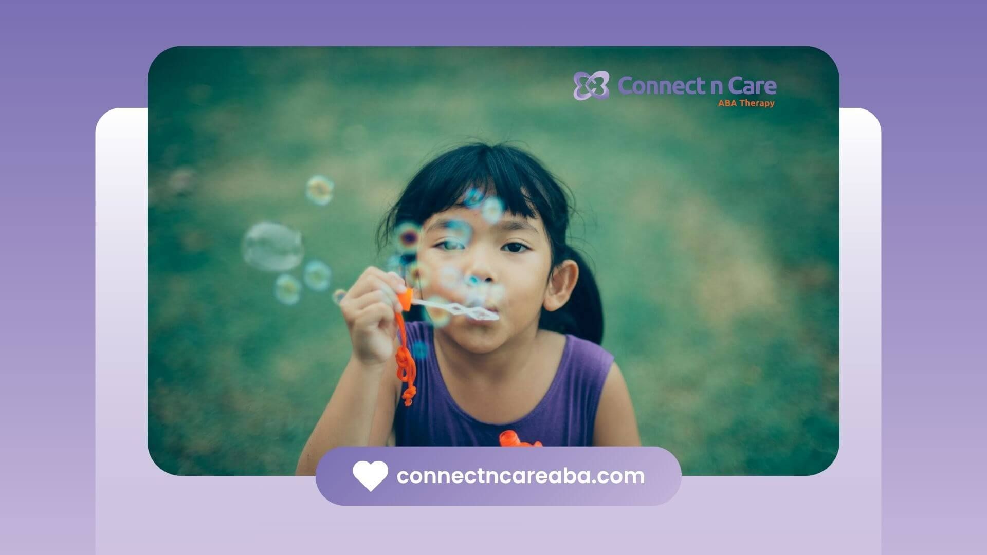 An autistic young girl blowing soap bubbles outdoors with a focused expression after ABA therapy.