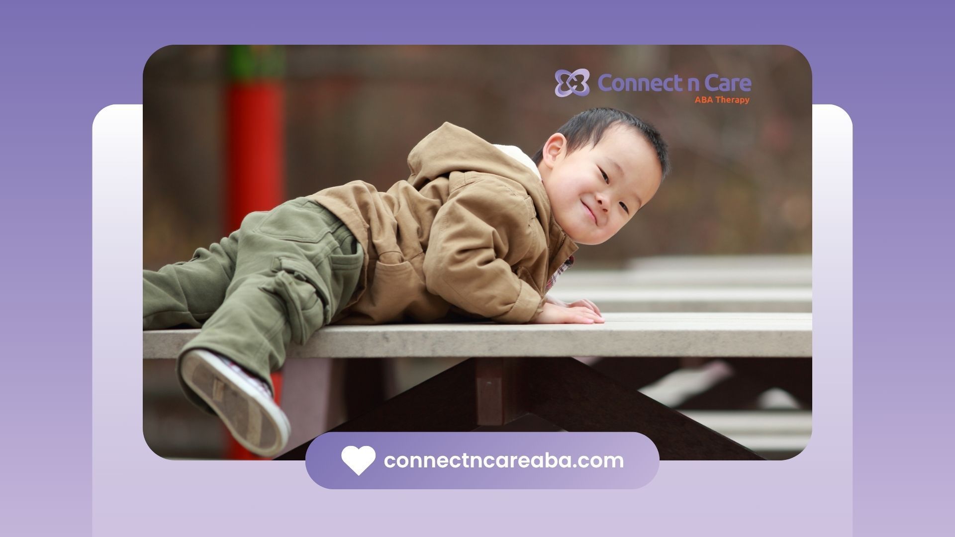 A young boy is laying on a picnic table.