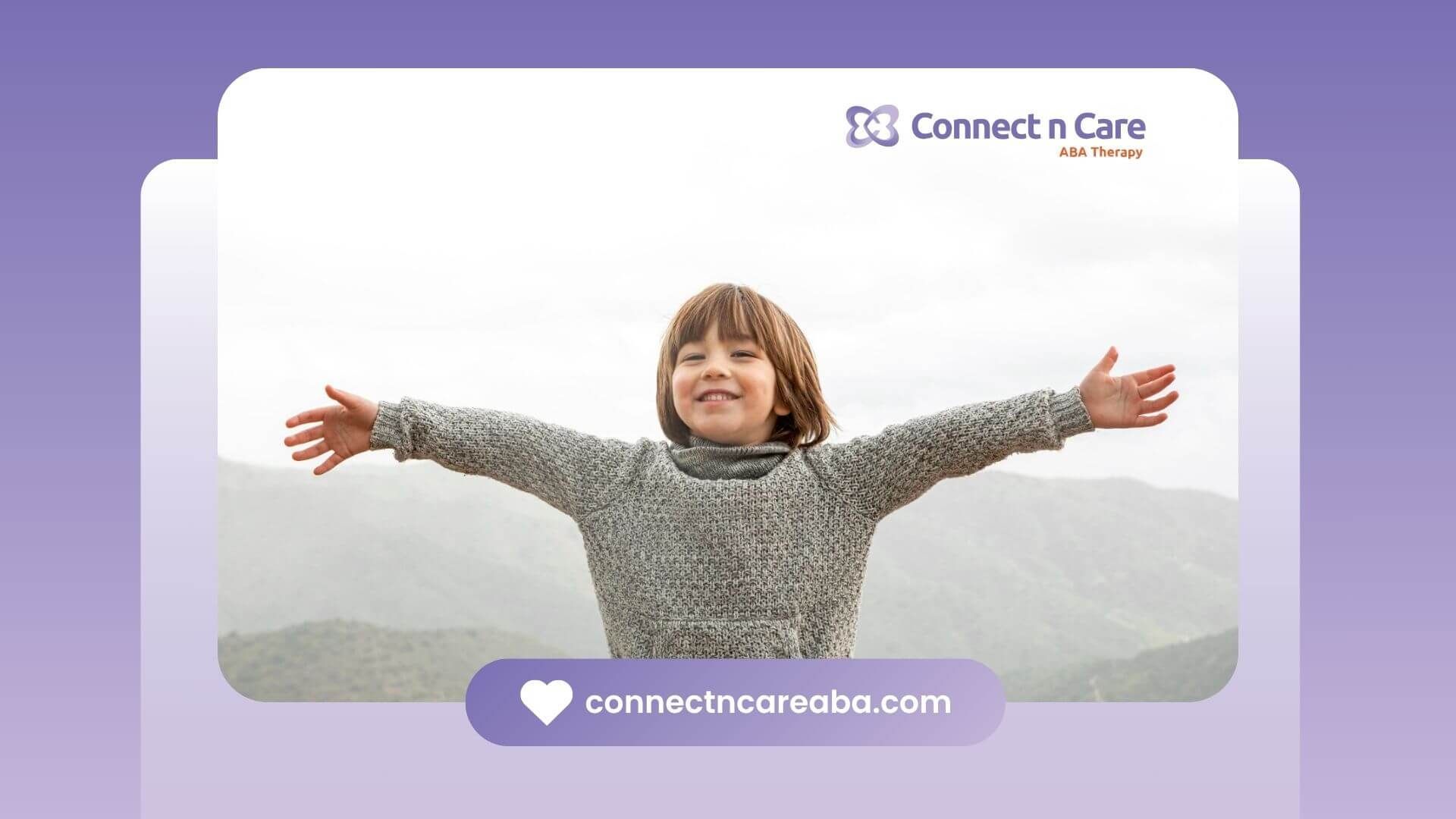 A young boy with autism in a sweater is standing with his arms outstretched.