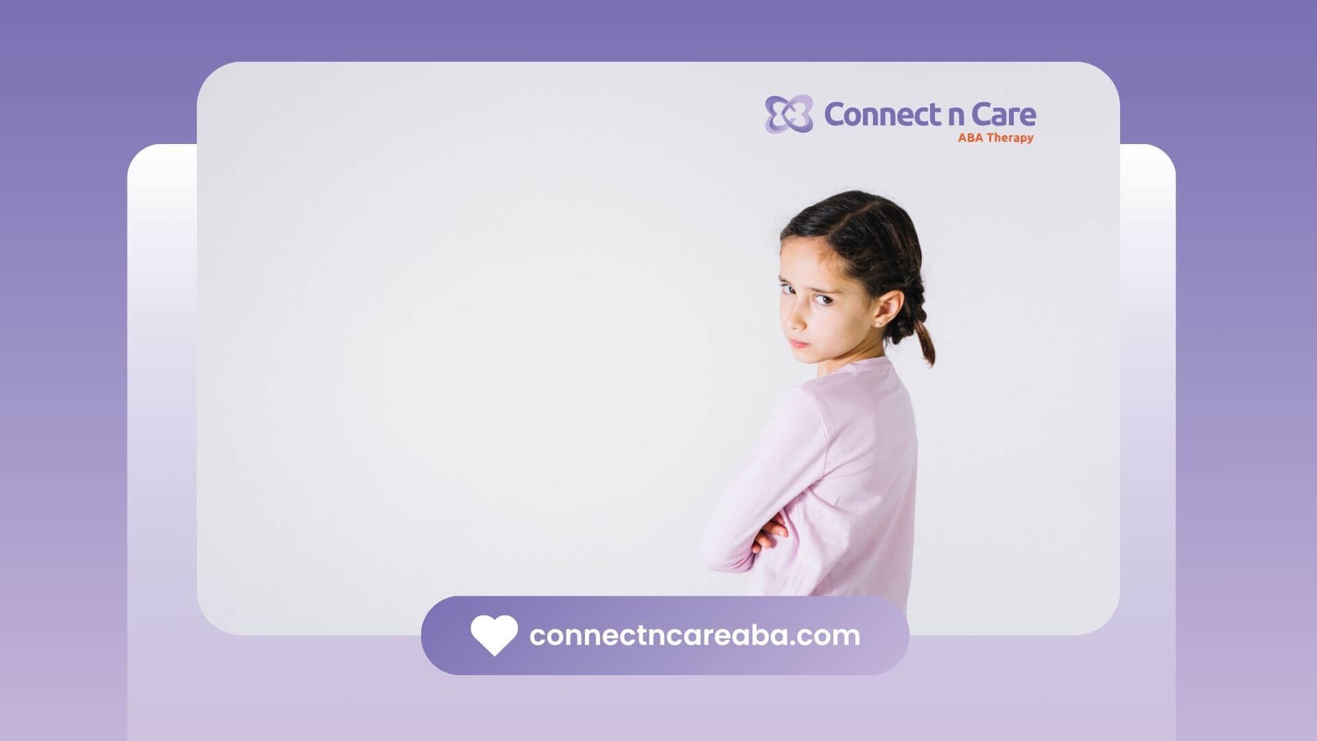 A little girl with braids is standing in front of a white background, looking upset.