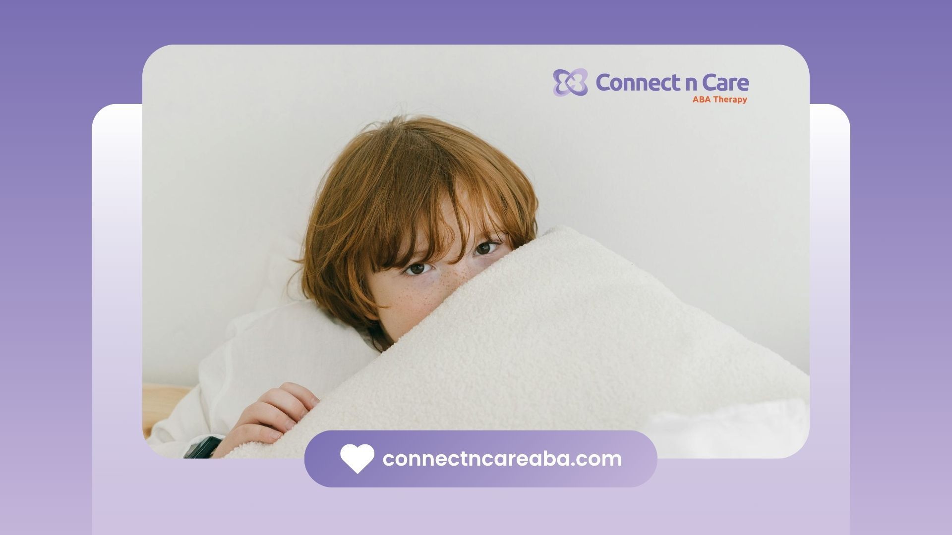 Red-haired autistic child peeking out from behind a white pillow in bed during ABA therapy in NC.