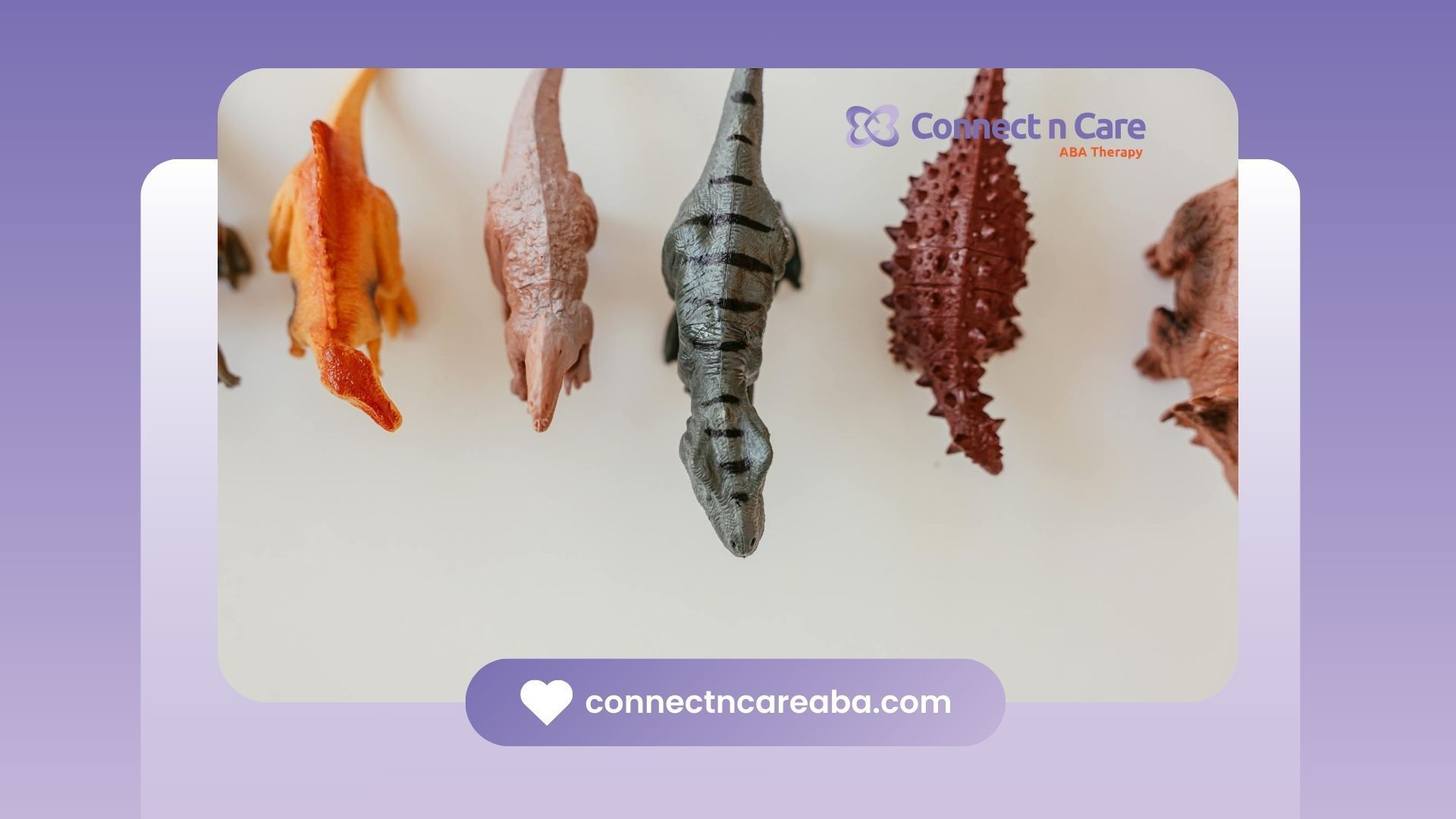 Toy dinosaurs arranged in a row on white surface arranged by autistic kid during ABA therapy in NC.