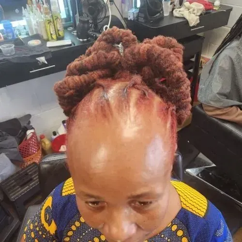 A woman with red hair is sitting in a chair in a salon.