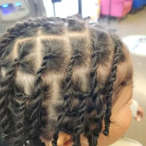 A close up of a child 's hair with braids.