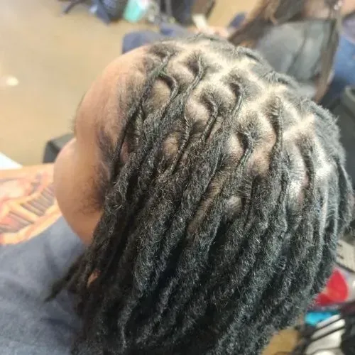 A close up of a person 's hair with dreadlocks.