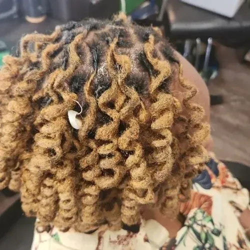 A close up of a person 's hair with dreadlocks.