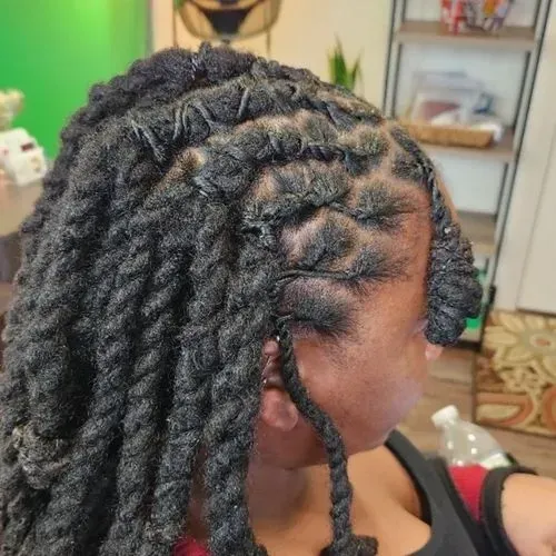 A woman with dreadlocks is wearing a black tank top.