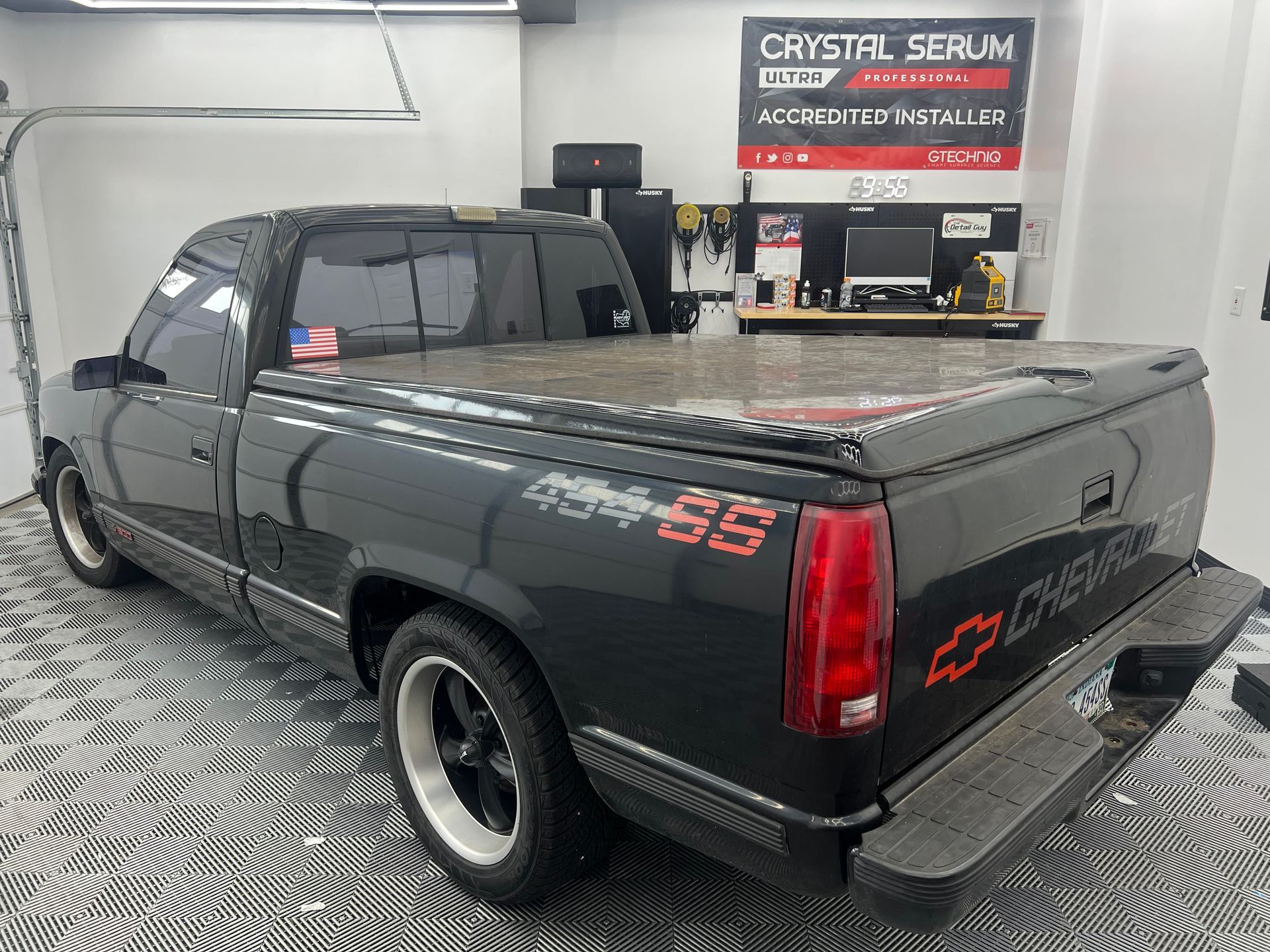 A black chevrolet truck is parked in a garage.