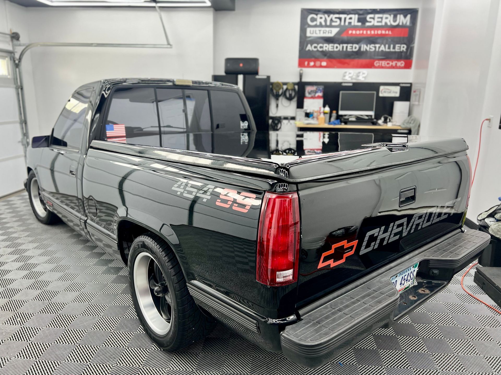 A black chevrolet truck is parked in a garage.