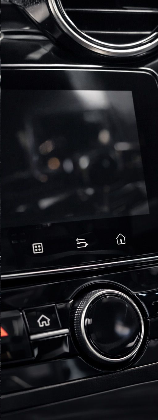 Car dashboard with a screen and a control knob.