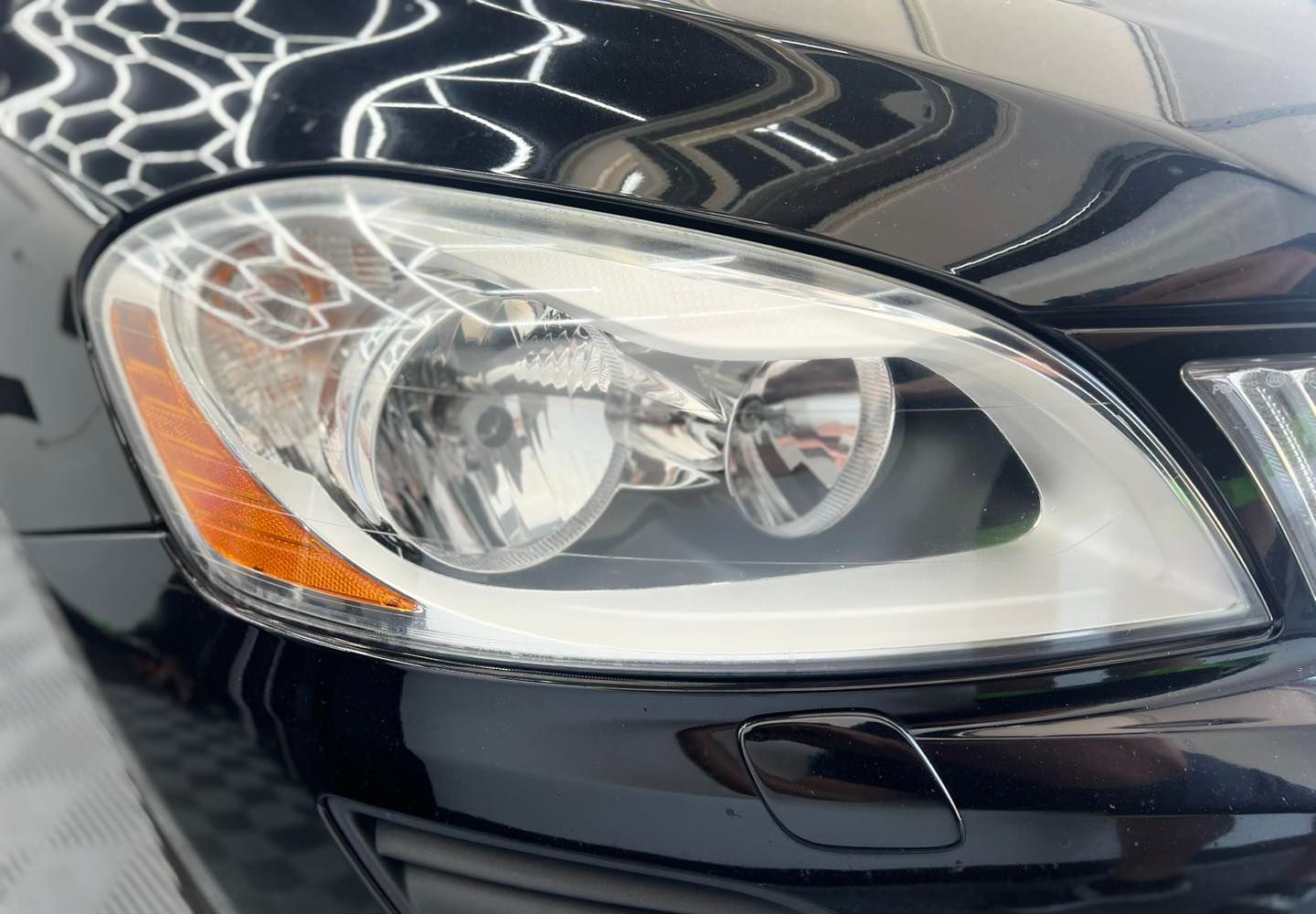 A close up of a black car 's headlight