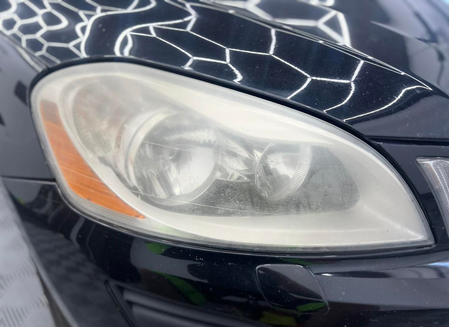 A close up of the headlight of a black car