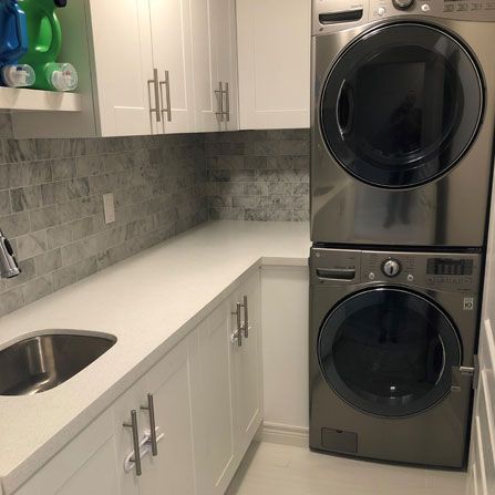 Newly renovated laundry room with washer, dryer, and cupboard space for storage