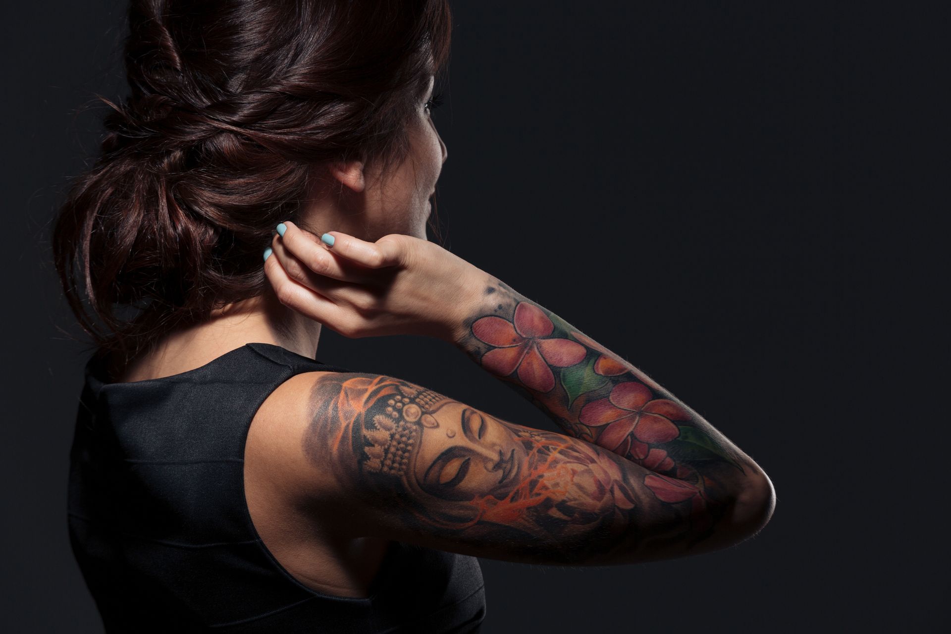 Back view of pretty young woman with tattooed hand.