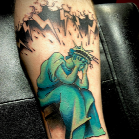 A tattoo of a statue of liberty with lightning bolts behind her