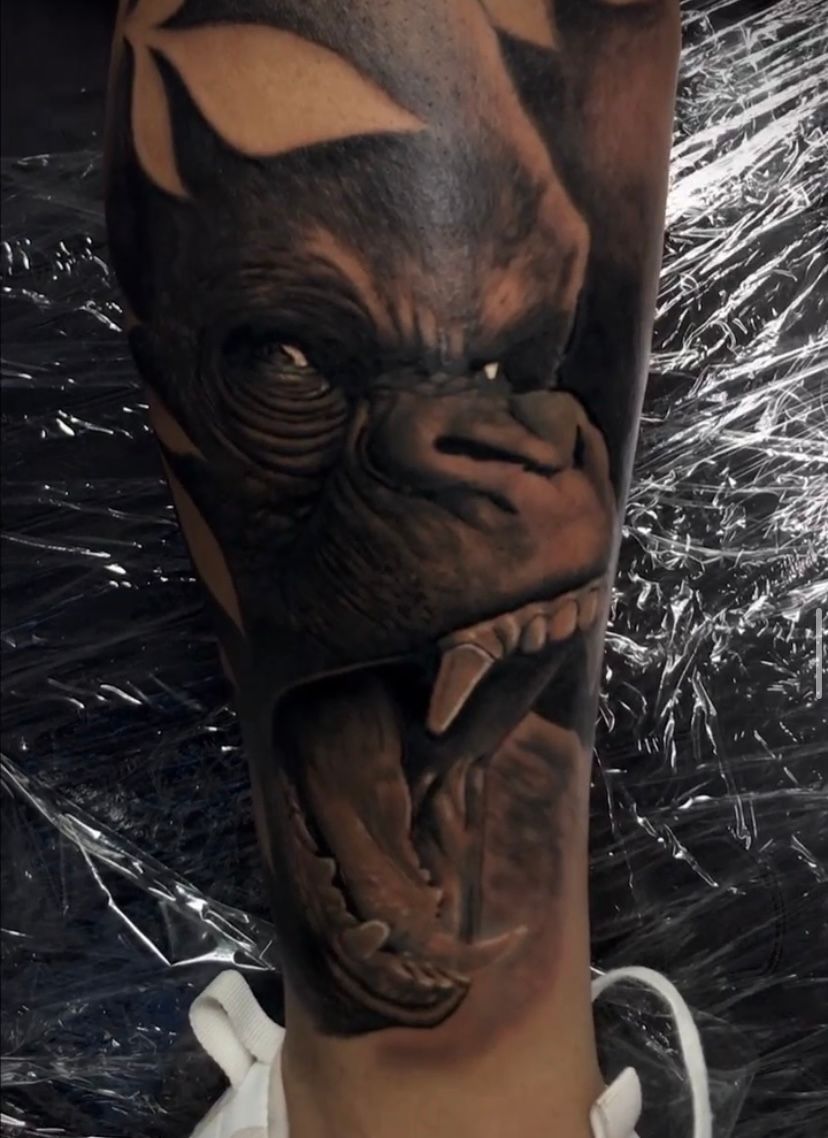 A person has a tattoo of a gorilla on their leg